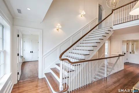 a view of a hallway with wooden floor and staircase
