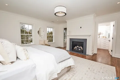 a spacious bathroom with double vanity a toilet a a sink a large mirror a bathtub and window