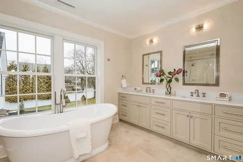 a white bath tub sitting in a bathroom next to a window