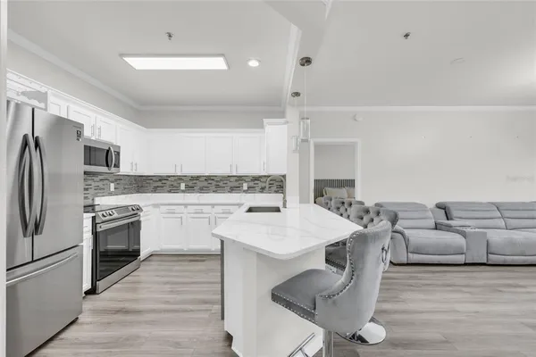 a kitchen with stainless steel appliances granite countertop a kitchen island hardwood floor sink and stove