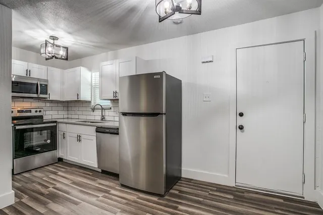 a kitchen with stainless steel appliances a refrigerator sink and microwave