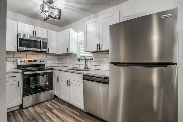 a kitchen with stainless steel appliances and refrigerator