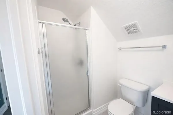 a white toilet sitting next to a shower