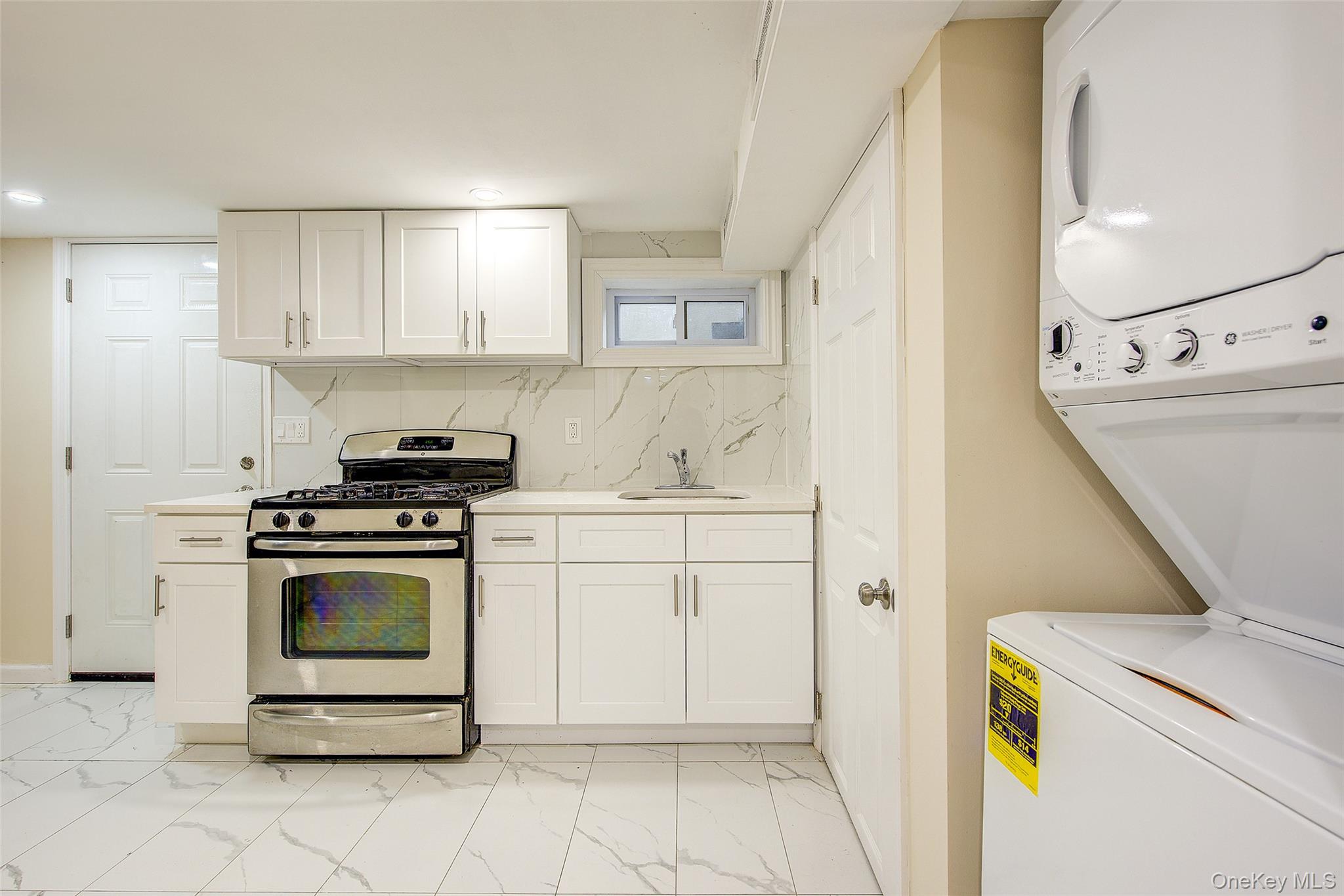 164-38 76th Road Queens, NY 11366 - Photo 27 of 44 a kitchen with a stove a sink and a refrigerator