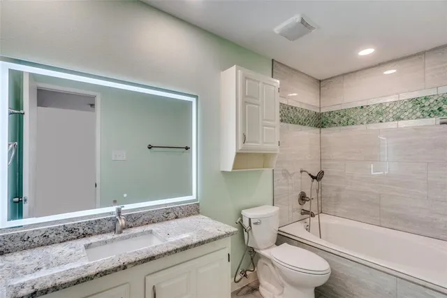 a bathroom with a granite countertop sink toilet and shower