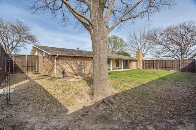 a view of a yard with a house and a tree