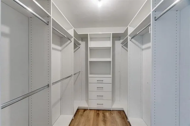 a view of walk in closet with empty racks