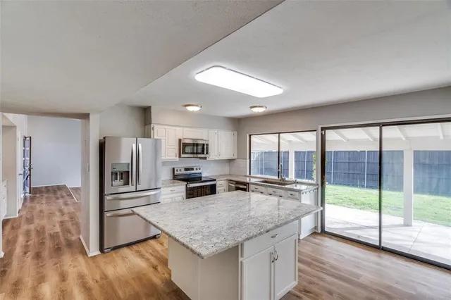 a kitchen with kitchen island a counter top space appliances and a counter space