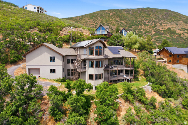 335 Bern Way Midway, UT 84049 - Photo 70 of 88 Multi-level hillside residence featuring a two-car garage, multiple balconies, integrated solar panels, and extensive window placement