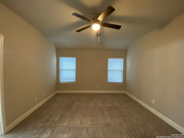 an empty room with a window and a fan