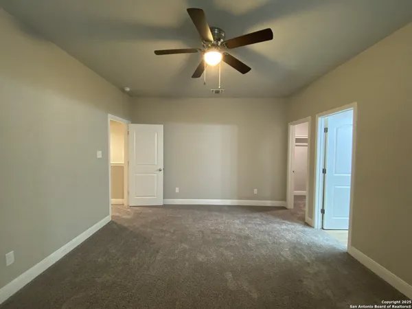 an empty room with closet and fan