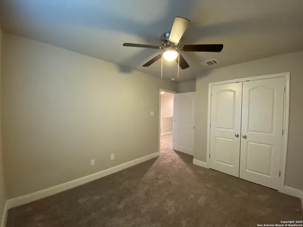 an empty room with a ceiling fan and a window