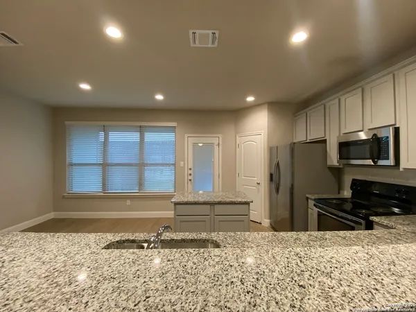 a view of a kitchen with a refrigerator and a sink