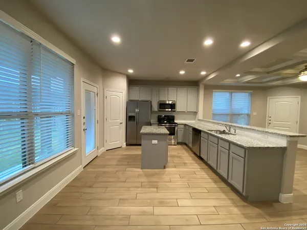 a large kitchen with stainless steel appliances lots of counter space and a sink