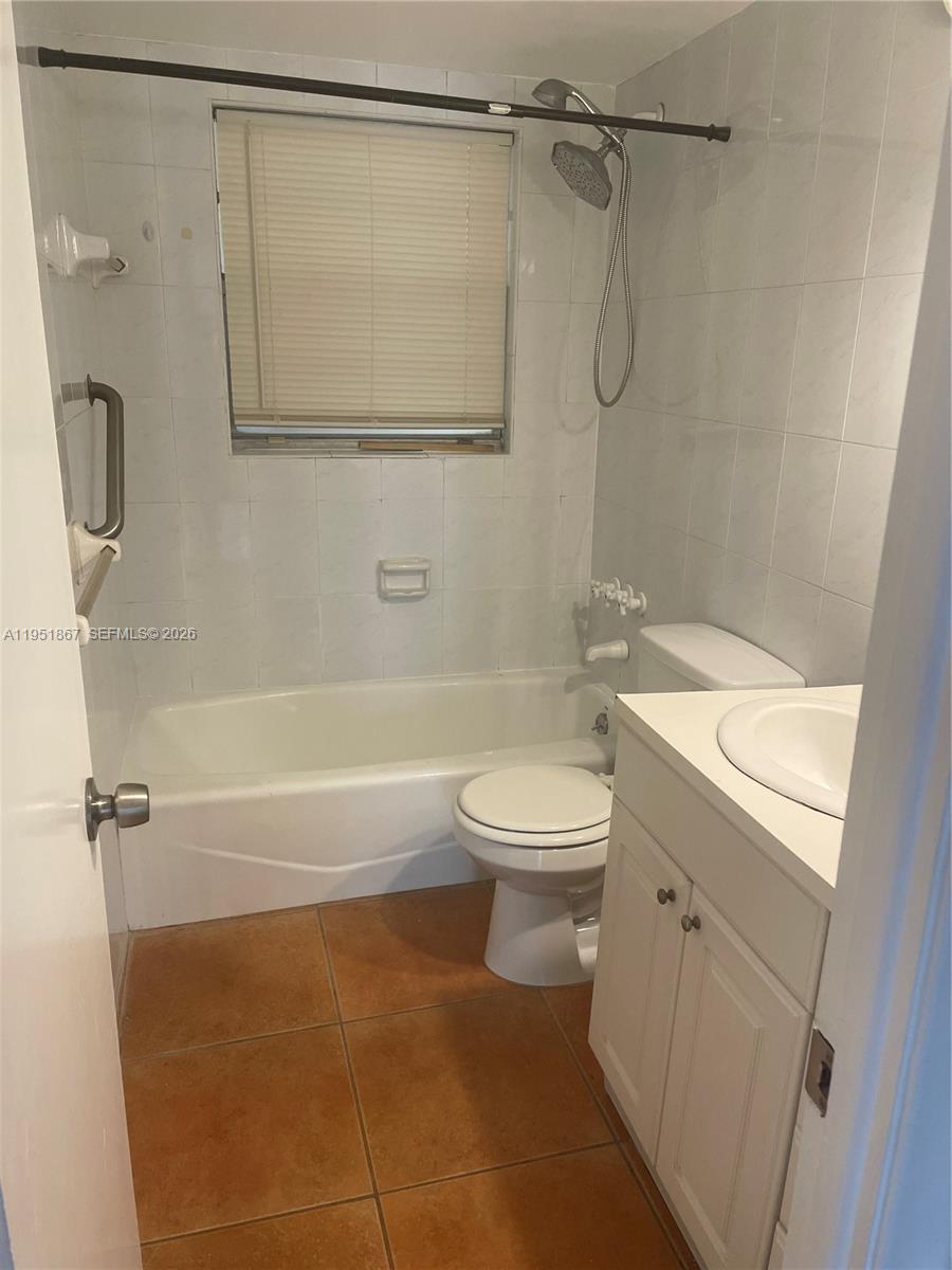 7785 Southwest 86th Street, Unit E123 Miami, FL 33143 - Photo 4 of 8 a bathroom with a shower a toilet and sink