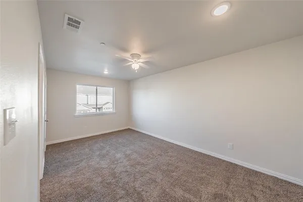 a view of an empty room with a ceiling fan