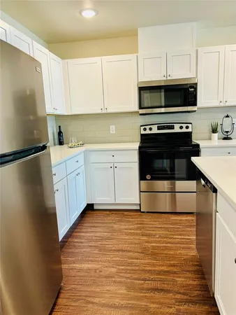 a kitchen with a sink stove and cabinets