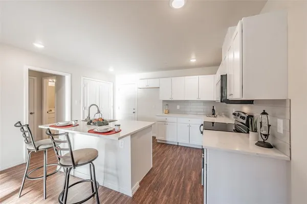 a kitchen with stainless steel appliances a stove microwave and sink