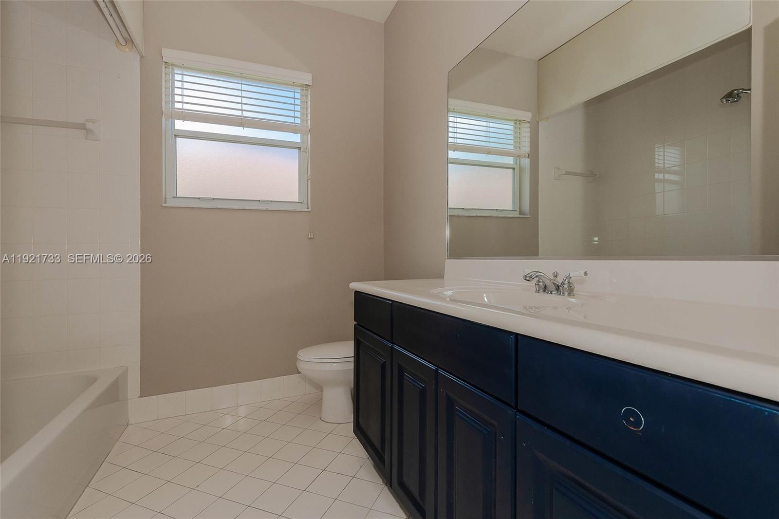 3843 Oak Ridge Circle Weston, FL 33331 - Photo 30 of 39 a bathroom with a sink a toilet and a window