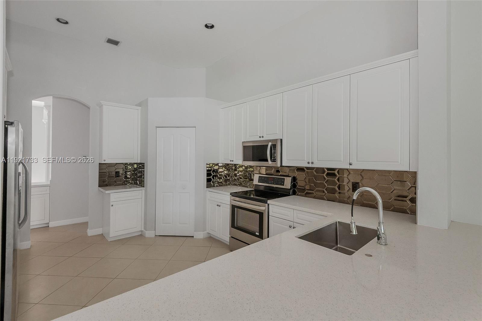 3843 Oak Ridge Circle Weston, FL 33331 - Photo 5 of 39 a kitchen with stainless steel appliances granite countertop a sink stove and refrigerator