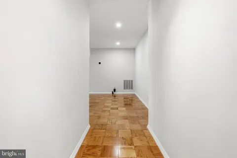 a view of a hallway with wooden floor