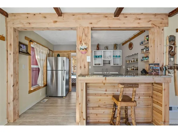 a kitchen with stainless steel appliances kitchen island granite countertop a refrigerator and cabinets