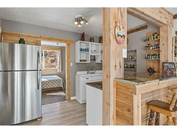 a kitchen view with stainless steel appliances granite countertop a refrigerator and a stove top oven