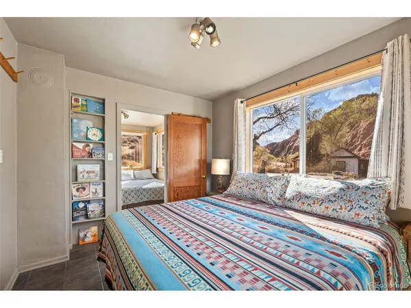 a bedroom with a bed and a dresser next to a window