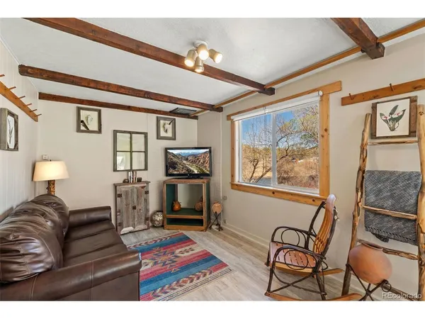a living room with furniture a rug and a painting on the wall