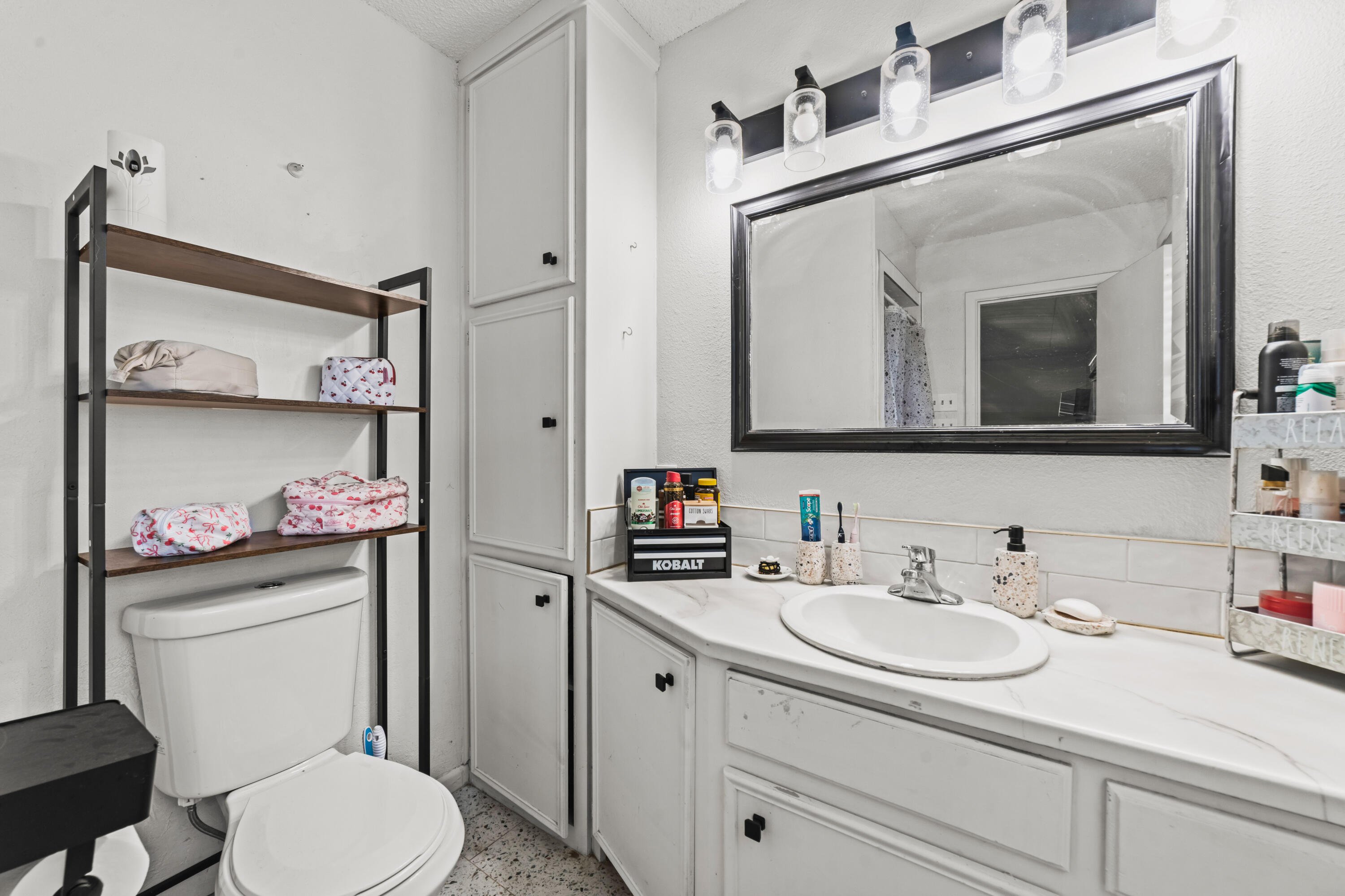 2510 59th Street Lubbock, TX 79413 - Photo 20 of 22 a bathroom with a toilet sink vanity and mirror