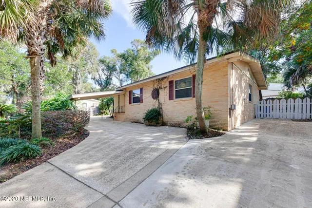 a view of a house with a yard and potted plants
