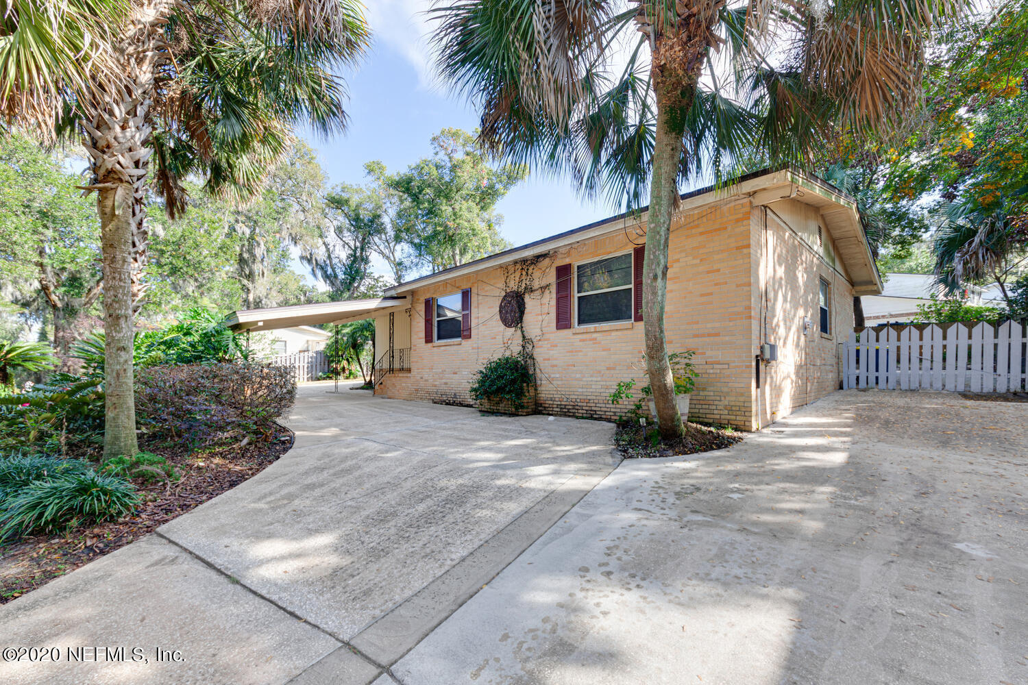 a view of a house with a yard and potted plants