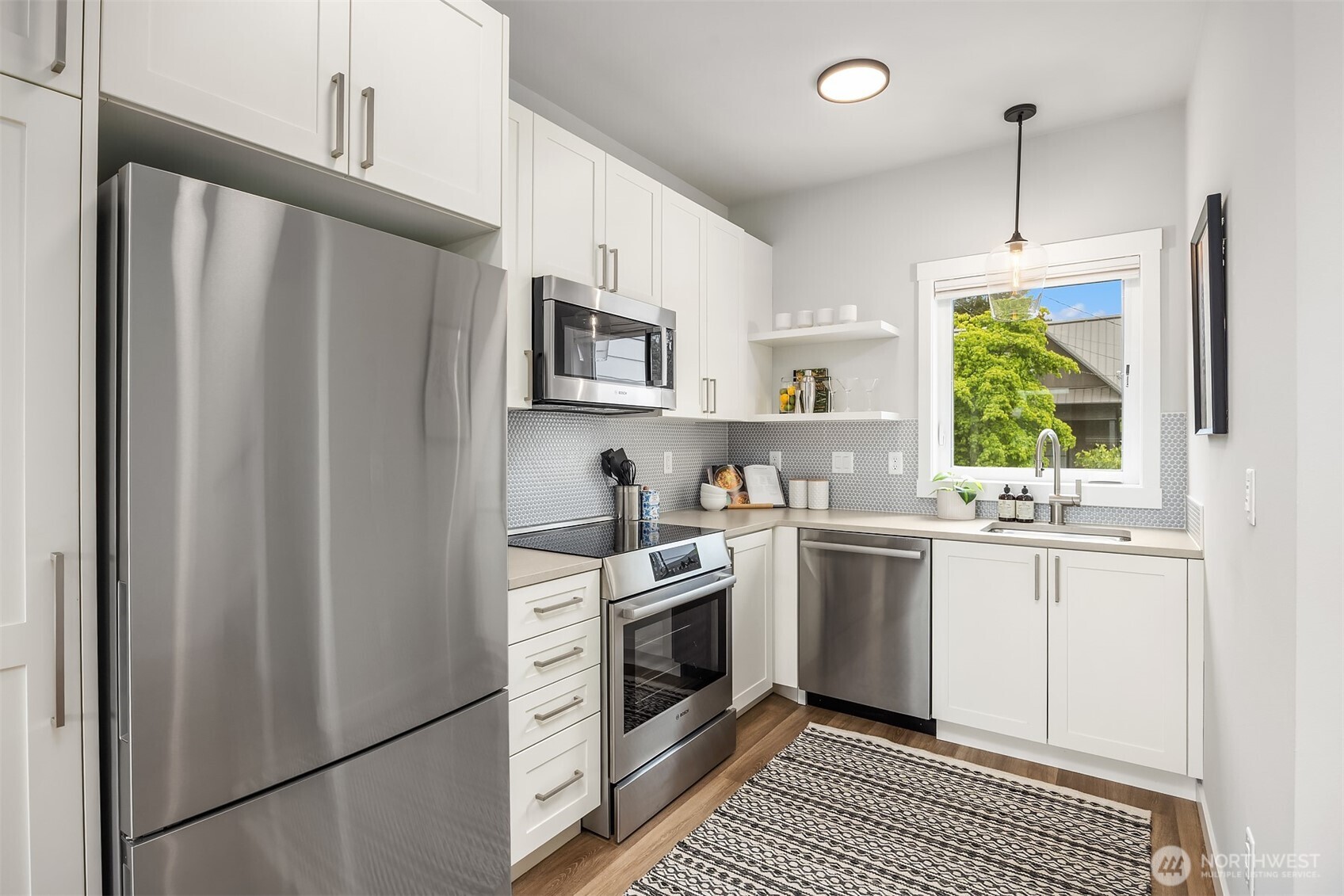 516 North 61st Street, Unit B Seattle, WA 98103 - Photo 8 of 17 a kitchen with stainless steel appliances granite countertop a stove a sink and a refrigerator