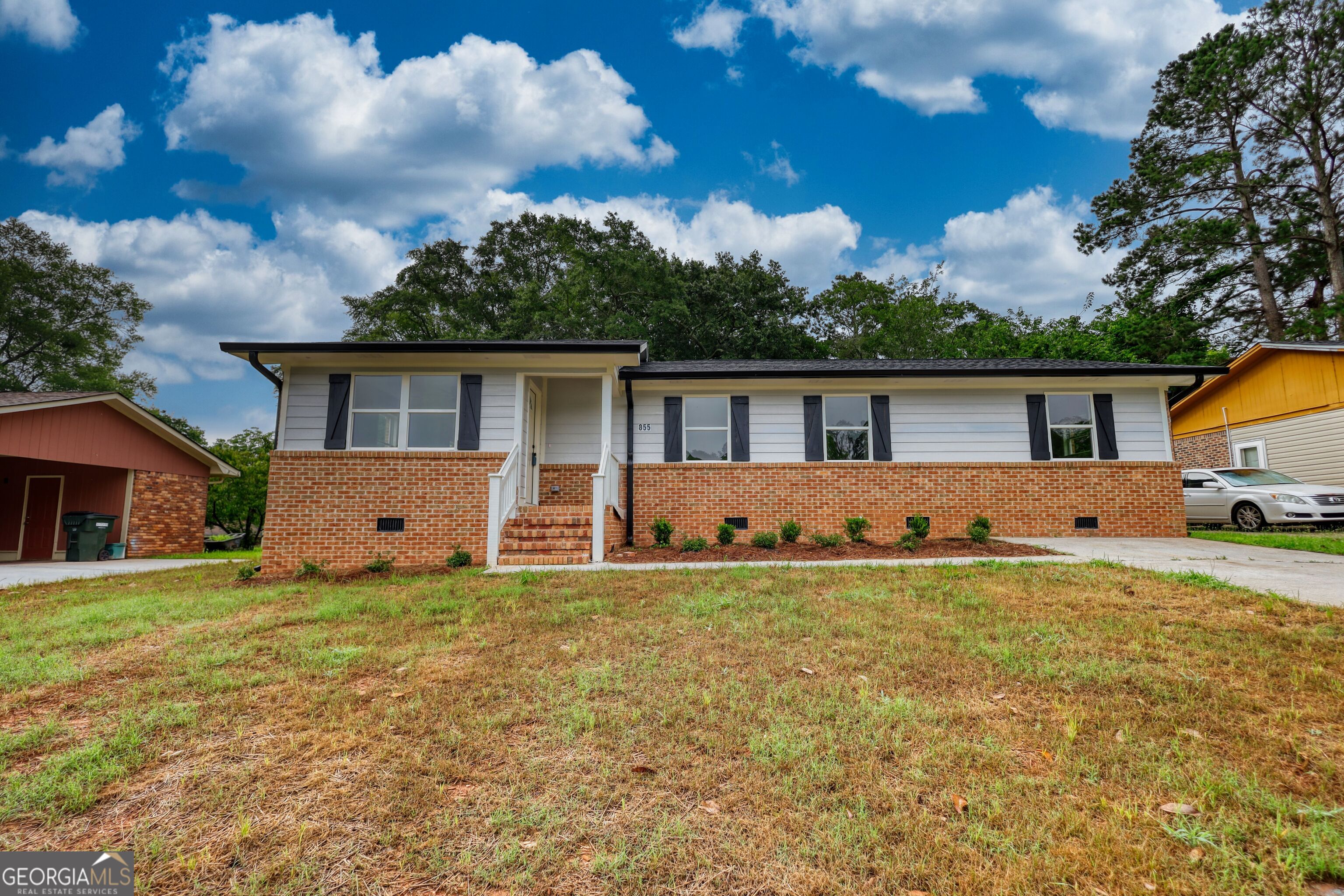 a front view of house with yard and trees around