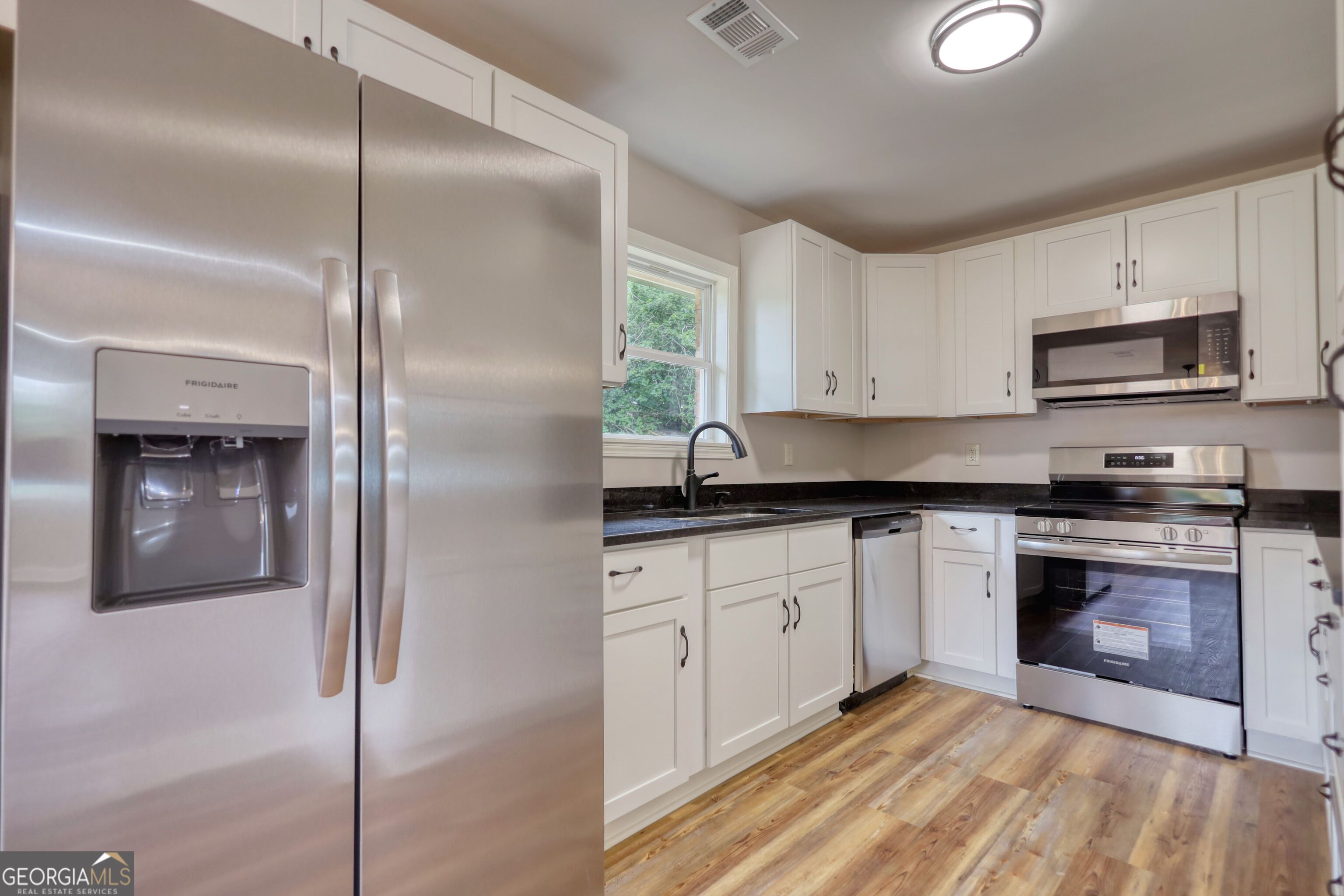 855 Meadow Ridge Drive Madison, GA 30650 - Photo 12 of 41 a kitchen with stainless steel appliances granite countertop a stove a sink and a refrigerator