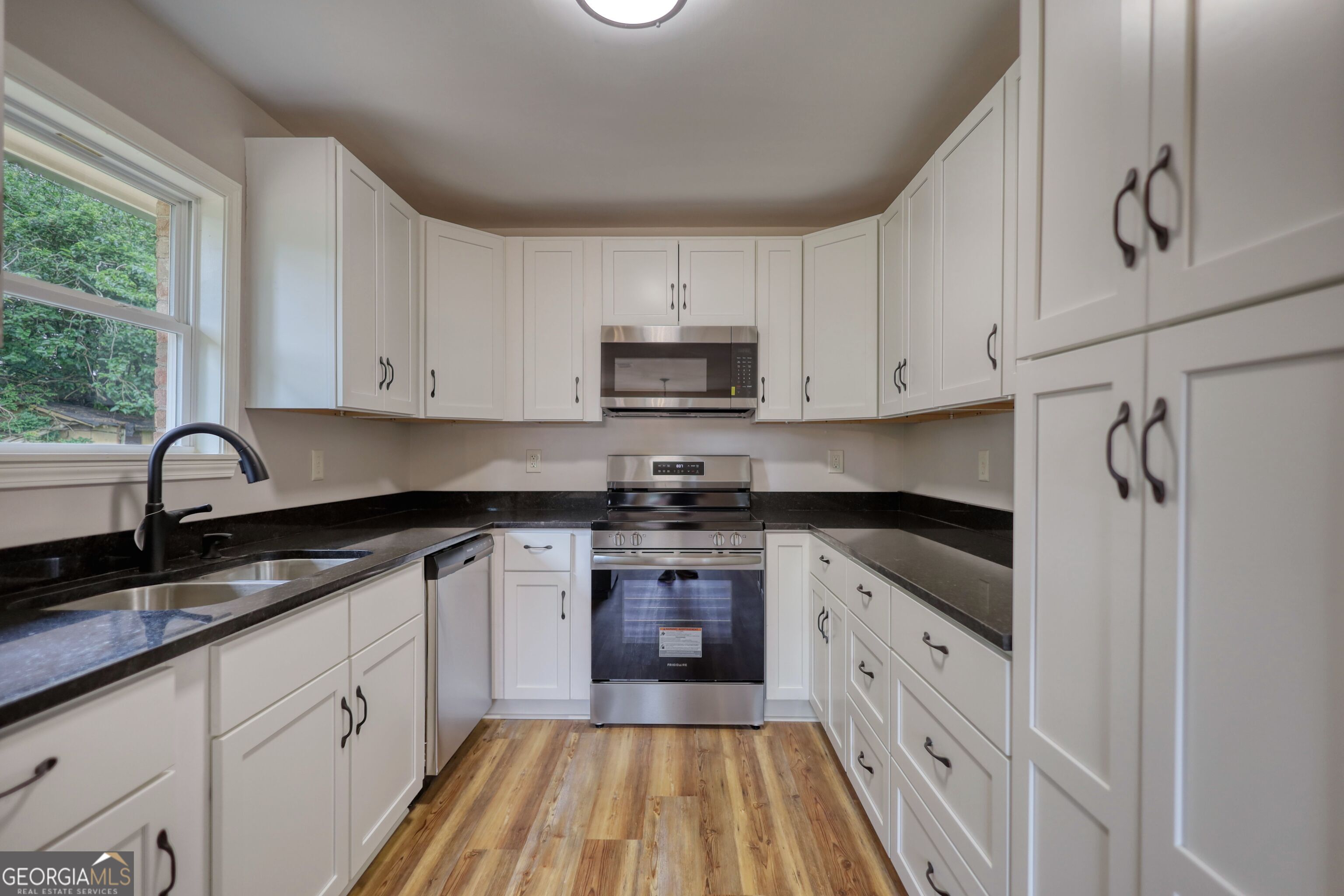 855 Meadow Ridge Drive Madison, GA 30650 - Photo 14 of 41 a kitchen with granite countertop white cabinets and stainless steel appliances