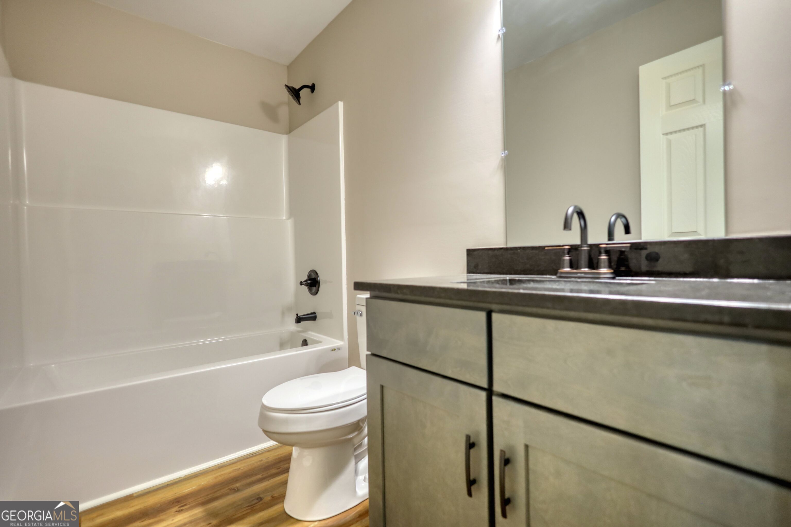 855 Meadow Ridge Drive Madison, GA 30650 - Photo 21 of 41 a bathroom with a granite countertop sink toilet a mirror and shower