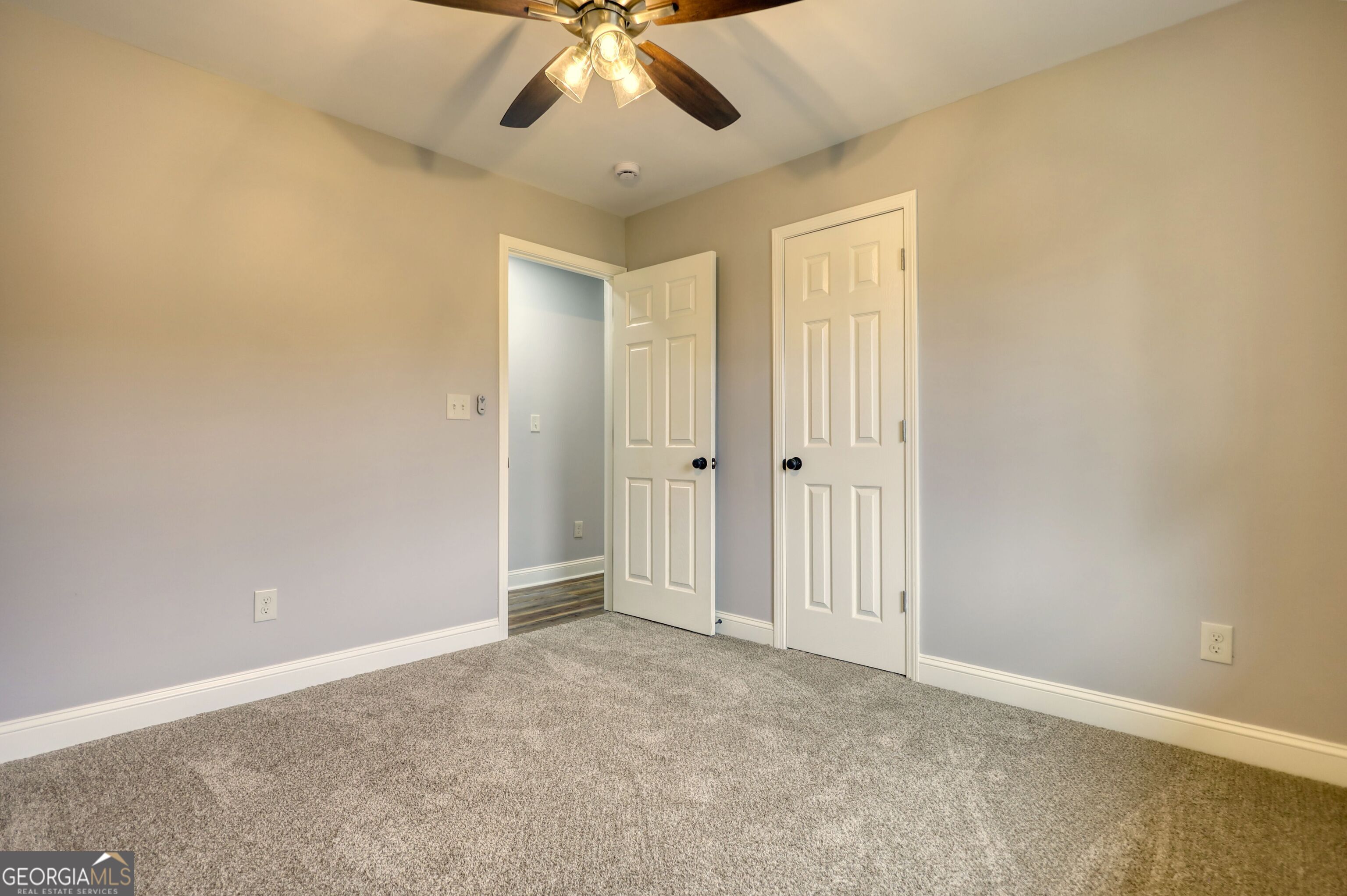 855 Meadow Ridge Drive Madison, GA 30650 - Photo 28 of 41 an empty room with a chandelier fan and windows