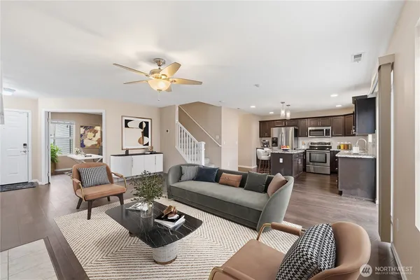 a living room with furniture kitchen view and a chandelier