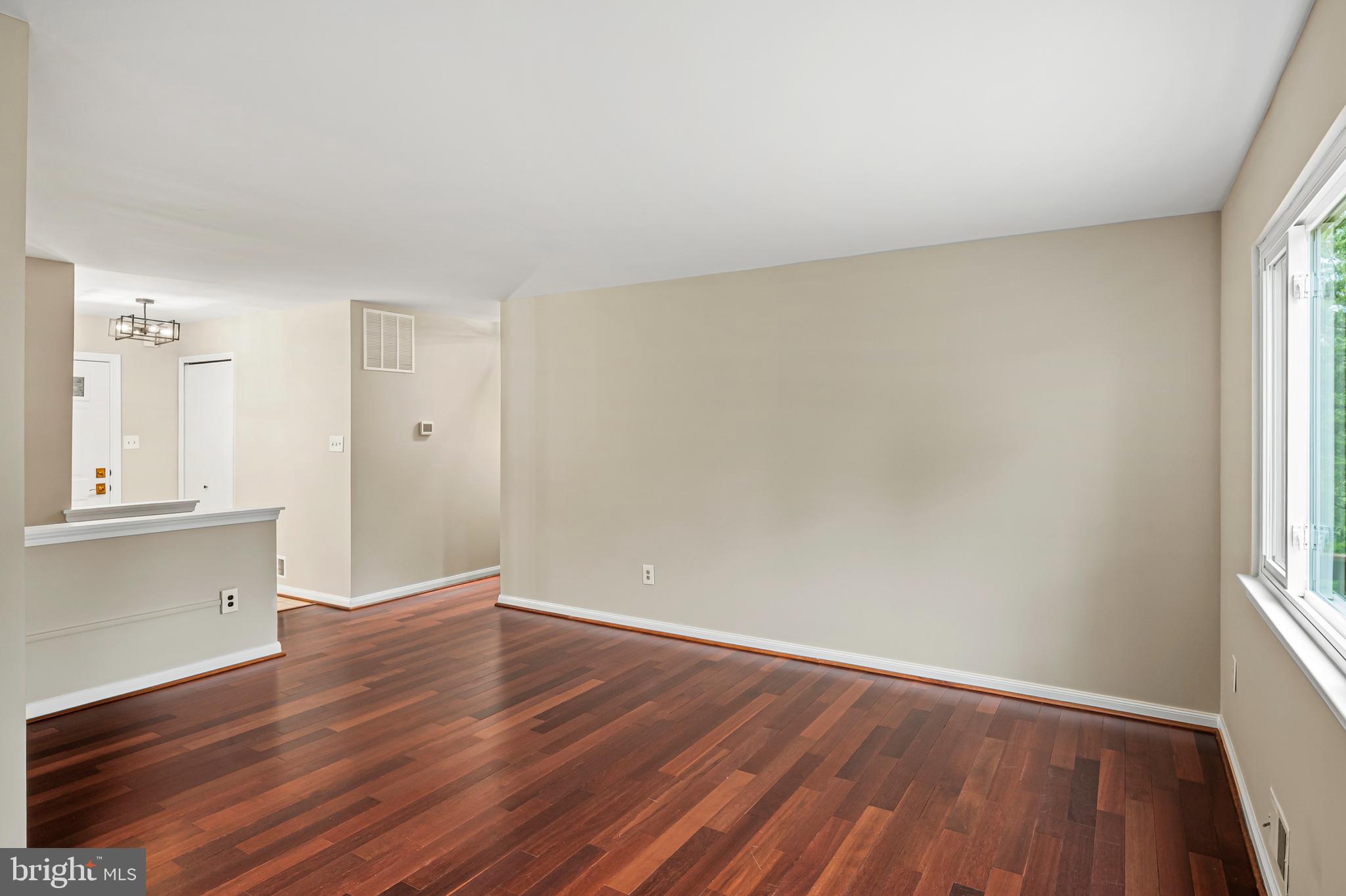 6411 Darwin Road Laurel, MD 20707 - Photo 13 of 41 an empty room with wooden floor and windows