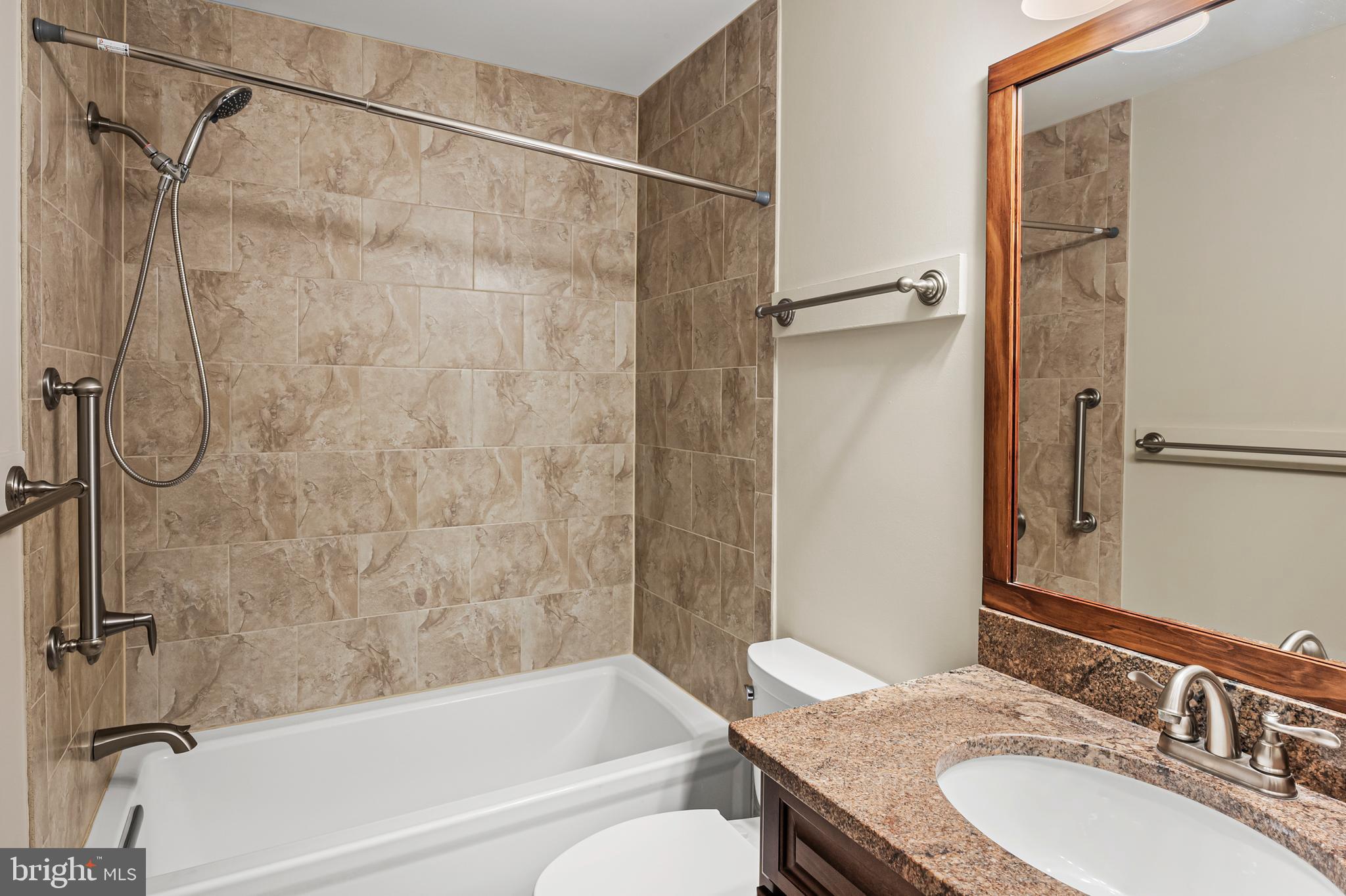 6411 Darwin Road Laurel, MD 20707 - Photo 22 of 41 a bathroom with a granite countertop bathtub shower sink vanity and toilet
