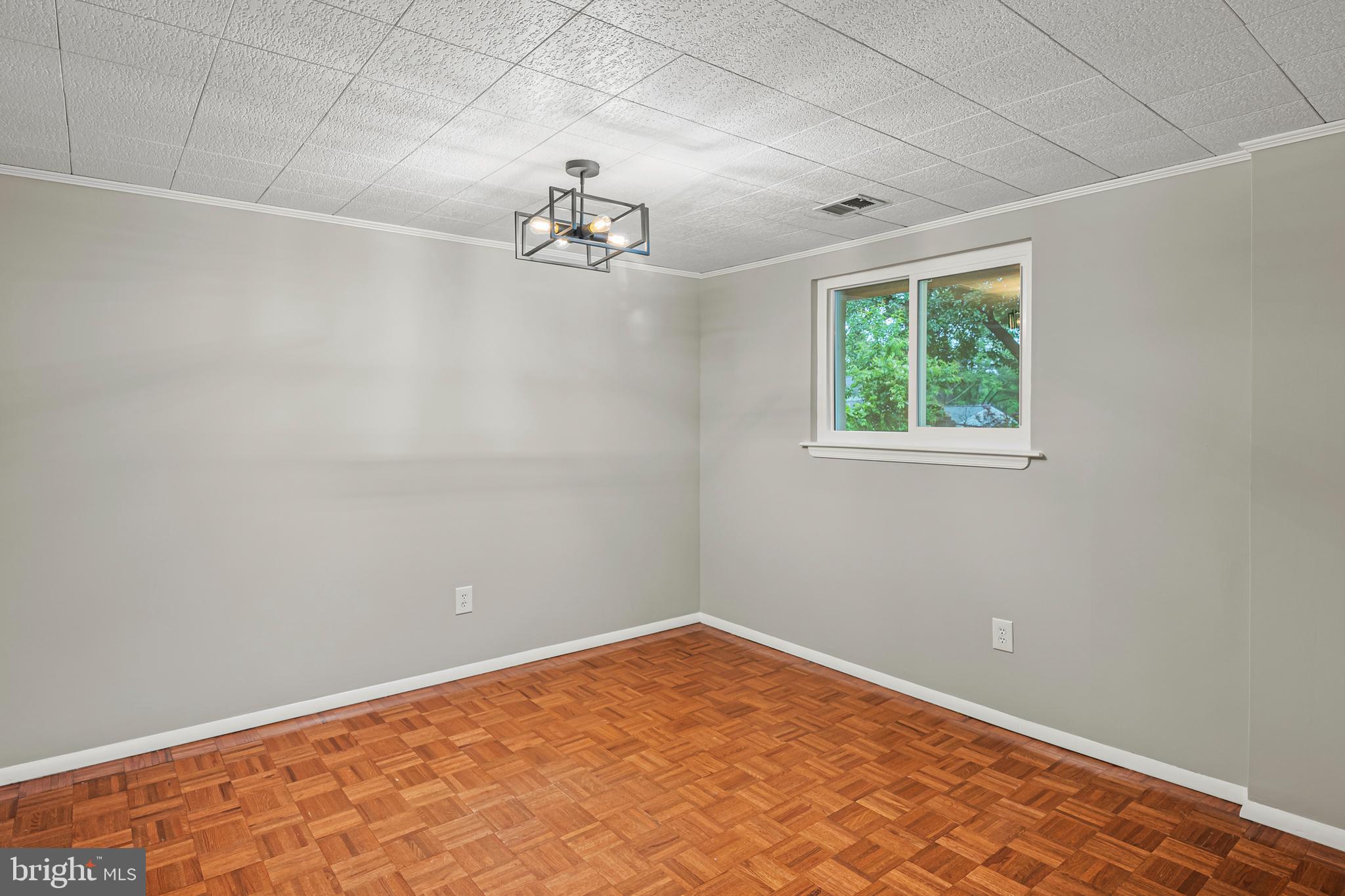 6411 Darwin Road Laurel, MD 20707 - Photo 26 of 41 an empty room with a chandelier fan and windows