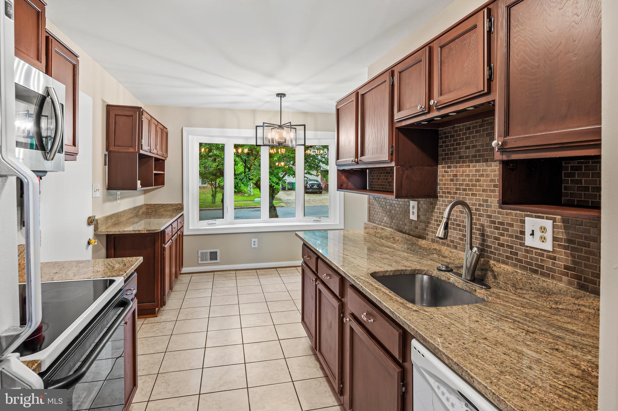 6411 Darwin Road Laurel, MD 20707 - Photo 9 of 41 a kitchen with stainless steel appliances granite countertop a sink stove and refrigerator