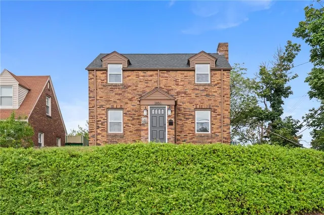 a brick building with green field in front of it
