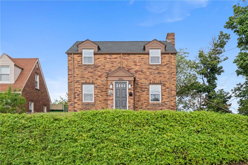 a brick building with green field in front of it