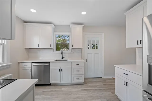 a kitchen with a sink cabinets and wooden floor