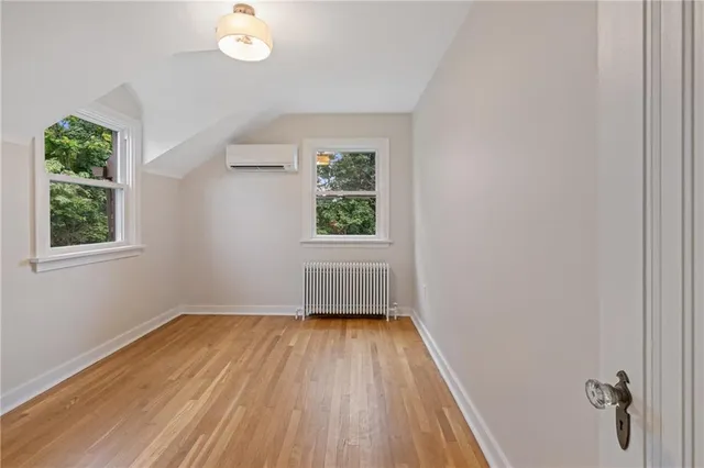 a view of a hallway with wooden floor and a window