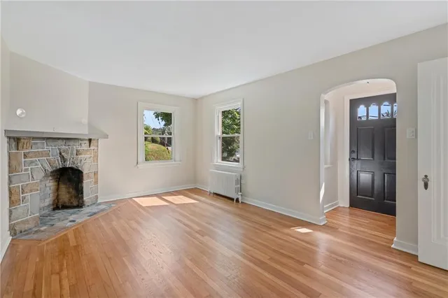 a view of an empty room with window and a fireplace