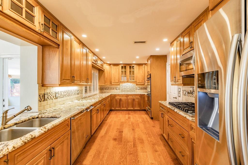 2650 Northeast 52nd Street Lighthouse Point, FL 33064 - Photo 12 of 35 a large kitchen with stainless steel appliances a large window and a sink