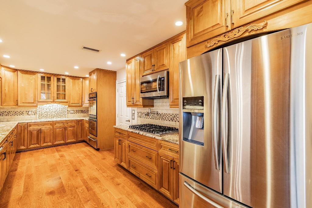 2650 Northeast 52nd Street Lighthouse Point, FL 33064 - Photo 16 of 35 a kitchen with stainless steel appliances granite countertop a refrigerator and a stove top oven